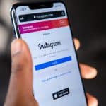 Instagram website open on an iPhone held by a human hand