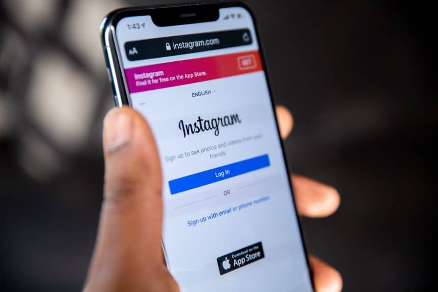 Instagram website open on an iPhone held by a human hand