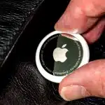 Close-up of an Apple AirTag being held.