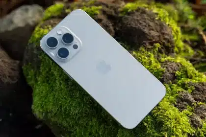 iPhone resting on moss-covered rocks.