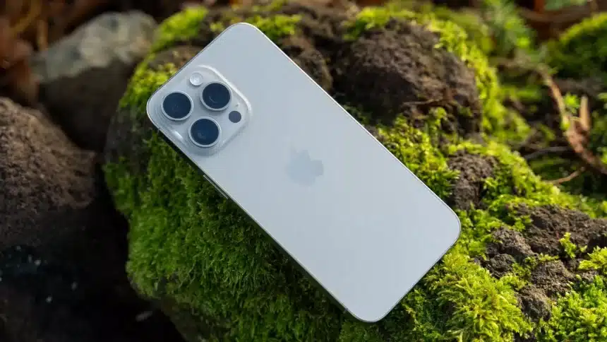 iPhone resting on moss-covered rocks.