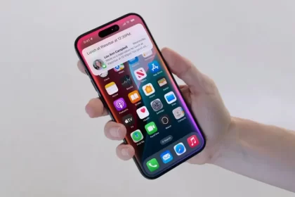 Hand holding an iPhone displaying iOS 18.1.