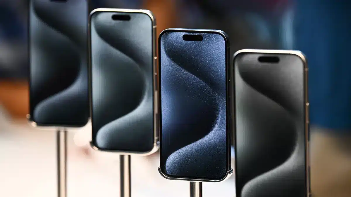 Four iPhones displayed on stands in a row.