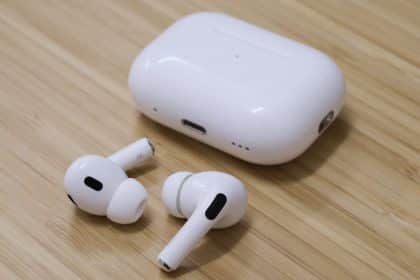 Apple AirPods Pro 2 with charging case on a wooden surface.