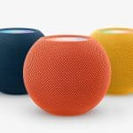 A lineup of colourful Apple HomePod mini speakers in different colours.