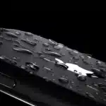 A close-up of a water-resistant iPhone with water droplets.