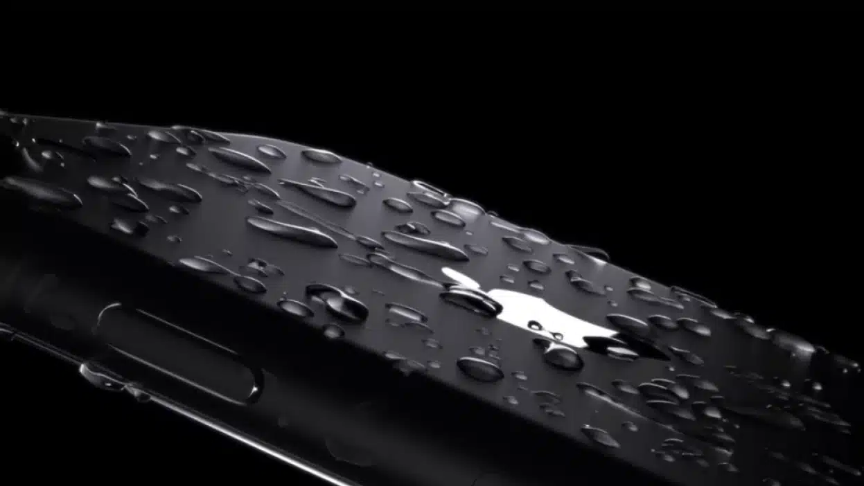 A close-up of a water-resistant iPhone with water droplets.