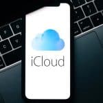 iPhone showing iCloud logo placed on a MacBook keyboard.