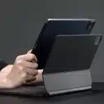 Person holding an iPad attached to a Magic Keyboard.