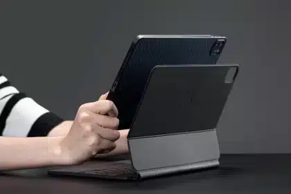 Person holding an iPad attached to a Magic Keyboard.