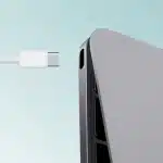 USB-C cable approaching a USB-C port on a laptop.