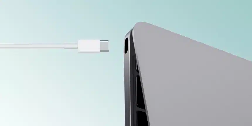 USB-C cable approaching a USB-C port on a laptop.