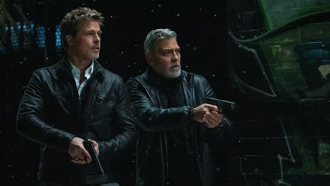 Brad Pitt and George Clooney holding guns from 'Wolfs'.