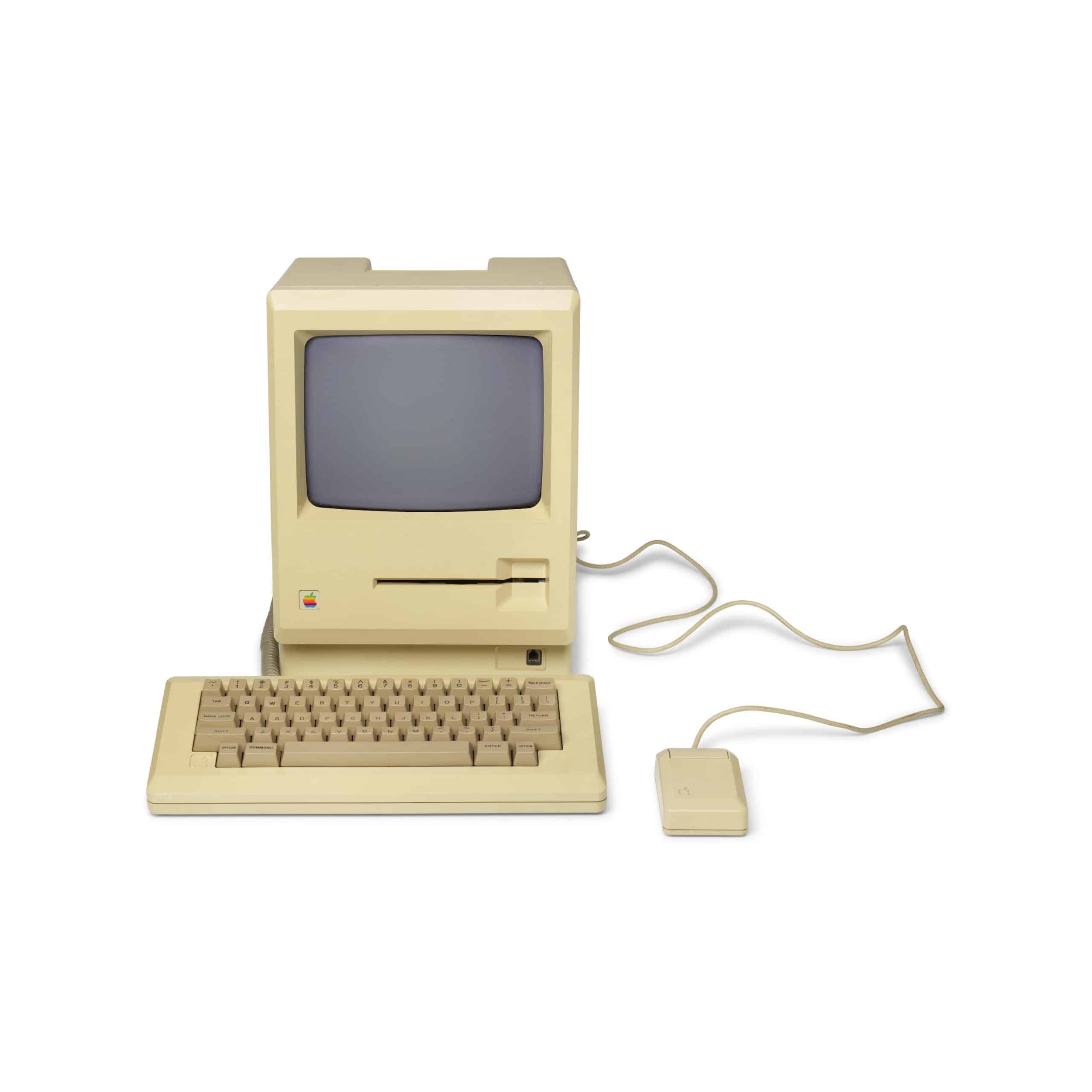 Vintage Apple Macintosh computer with keyboard and mouse.