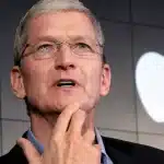 Tim Cook speaking in front of the Apple logo.