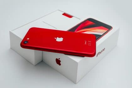 Red iPhone SE placed on its box.