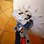 Technician working on a satellite installation inside a large dome.