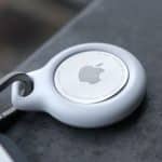 Close-up of an Apple AirTag attached to a keychain.