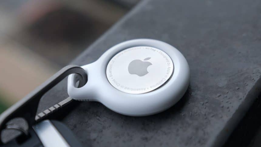 Close-up of an Apple AirTag attached to a keychain.