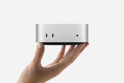 A hand holding the M4 Mac mini.