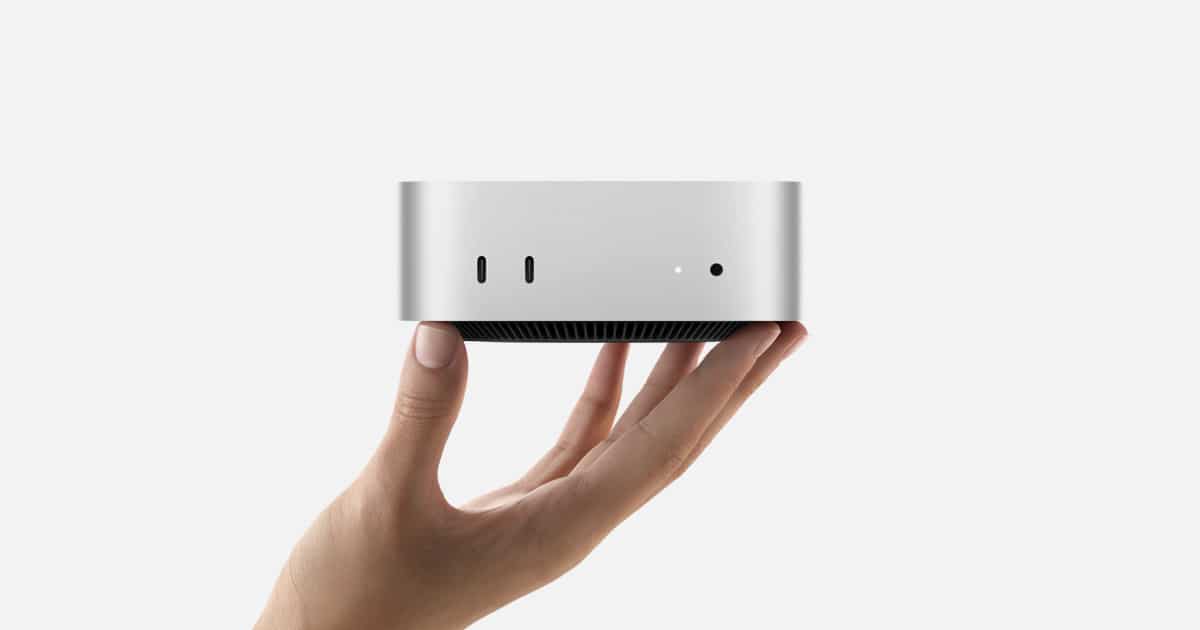 A hand holding the M4 Mac mini.