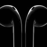 Close-up of black AirPods on a dark background.