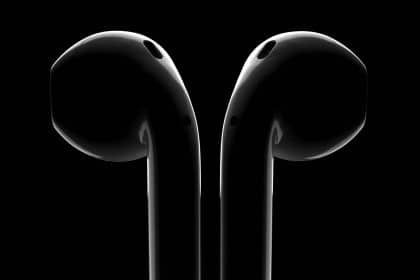 Close-up of black AirPods on a dark background.