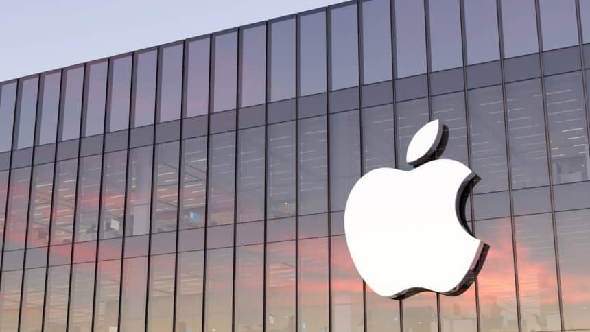 Apple logo on a glass building at sunset.