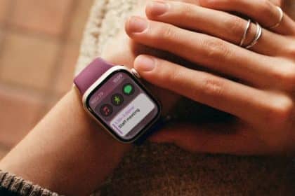 A person wearing an Apple Watch with a purple band.