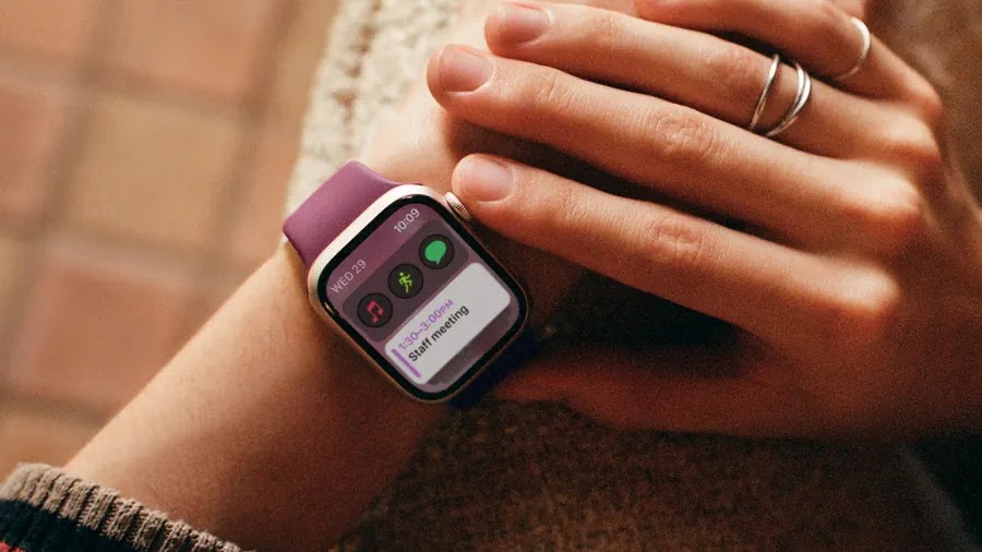 A person wearing an Apple Watch with a purple band.