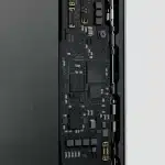 A close-up view of an iPhone's internal circuit board, showing the next-gen C2 modem and electronic components.