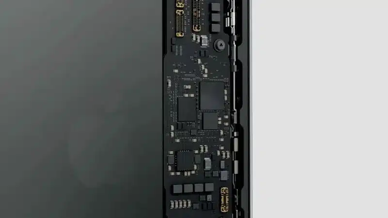 A close-up view of an iPhone's internal circuit board, showing the next-gen C2 modem and electronic components.