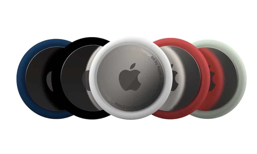 A set of Apple AirTags in various colours, including black, white, red, and green.