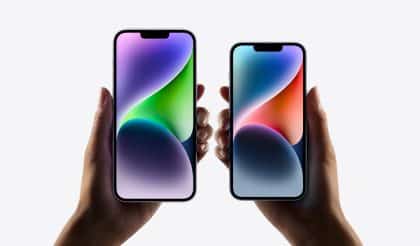 Two hands holding iPhone models with vibrant displays against a white background.