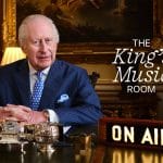 King Charles III hosting The King's Music Room on Apple Music 1, with an "On Air" sign in front of him.