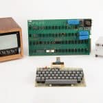 Vintage Apple-1 computer with monitor, circuit board, keyboard, and power supply.