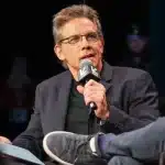 Ben Stiller speaking at SXSW, holding a microphone during a panel discussion.