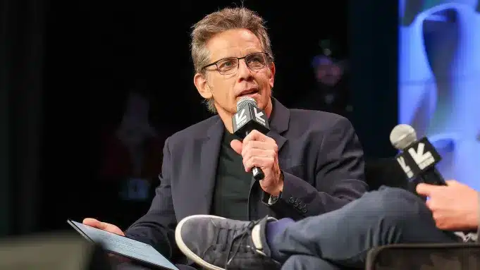 Ben Stiller speaking at SXSW, holding a microphone during a panel discussion.