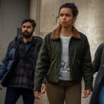 A group of four people looking tense and alert in an urban setting.