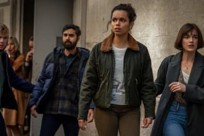 A group of four people looking tense and alert in an urban setting.