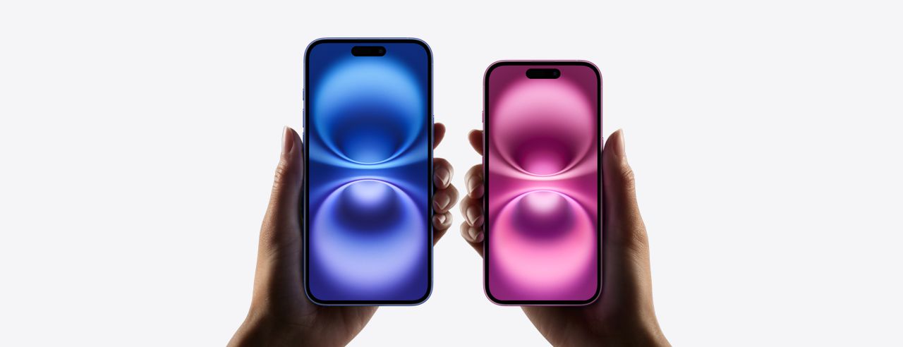 Two hands holding iPhone models in blue and pink with glowing wallpaper.