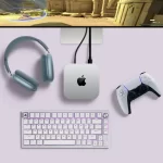 Apple Mac Mini setup with a gaming monitor, headphones, keyboard, and PlayStation controller.