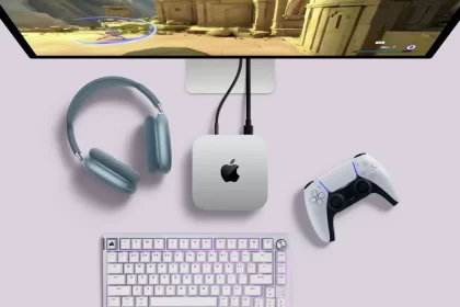 Apple Mac Mini setup with a gaming monitor, headphones, keyboard, and PlayStation controller.