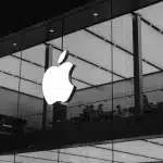 Black and white image of an Apple Store with a glowing Apple logo.