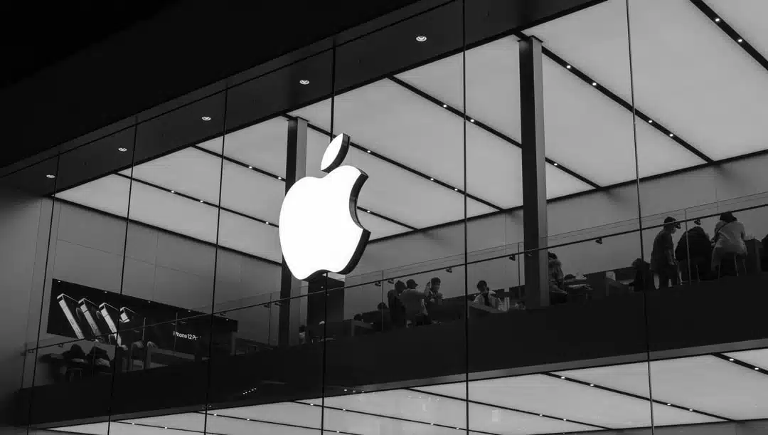 Black and white image of an Apple Store with a glowing Apple logo.